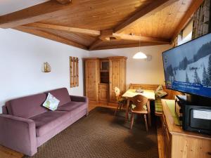 a living room with a purple couch and a table at Gästehaus Hölzl in Itter