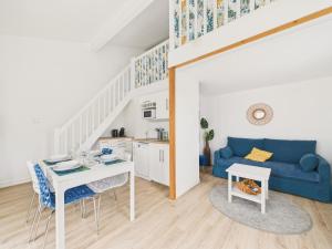 a living room with a blue couch and a table at Maison proche Golf plage et piscine à Pornic in Pornic