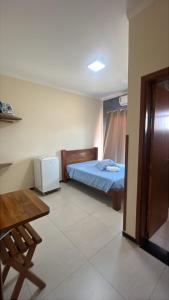 a bedroom with a bed and a desk and a table at Pousada Cabana in Avaré