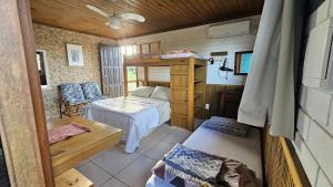 a small room with a bed and a table in a room at Casa Kitnet Loft Bidu House in Imbituba