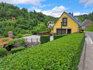 a yellow house on the side of a hill at Soba Erika in Fužine +16 photos