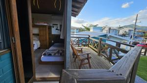 a balcony with a bed and chairs on a deck at Casa Kitnet Loft Bidu House in Imbituba