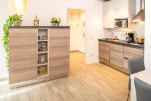 a kitchen with wooden cabinets and a counter top at MillyHolidays - Apartment Sunflower - Center - Nearby Beach - Private Garden - Spa Pool in Bardolino +35 photos
