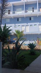 a large blue building with a palm tree in front of it at Studio Home Residence in Jacareí