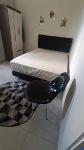 a black chair sitting on a bed in a room at Studio Home Residence in Jacareí +11 photos