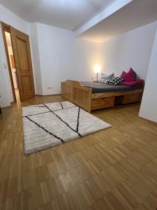 a bedroom with a bed with a rug on the floor at Ferienwohnung Schwarzwald - Nähe der Schweiz in Hüfingen
