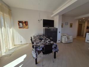 a table with chairs and a television in a room at Alloggio Ametista frontemare con posto auto in Lavagna +57 photos
