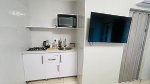 a small kitchen with a sink and a microwave at Mjee's Guest House in Ulundi