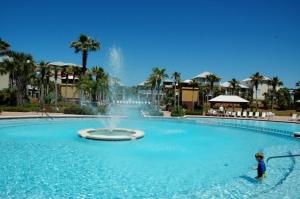 a child standing in a swimming pool with a fountain at Sea La Vie , Walk Everywhere in Rosemary Beach
