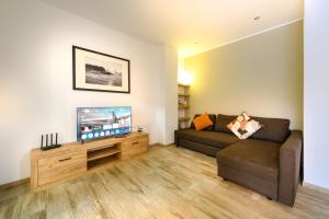 a living room with a couch and a flat screen tv at Casa Lina Tirano in Tirano