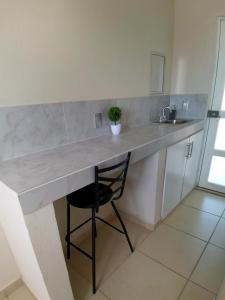 a kitchen with a counter with a chair and a sink at Villa platino in Pachuca de Soto