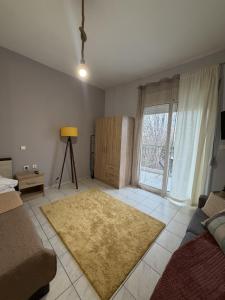 a living room with a couch and a large window at Dimi's home in Komotini