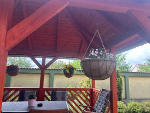 a gazebo with a table and a hanging flower basket at Aranyhaj Apartman in Debrecen +2 photos