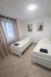 two beds in a room with a window at Apartment für Monteure & Gruppen in Koblenz-Ehrenbreitstein in Koblenz