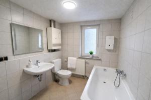 a bathroom with a sink and a toilet and a tub at Apartment für Monteure & Gruppen in Koblenz-Ehrenbreitstein in Koblenz