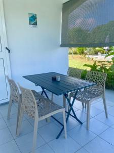 a blue table and chairs on a patio at Mango-passion Le Domaine Mannou in Sainte-Rose