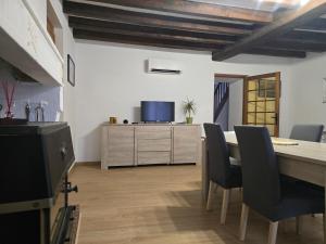 a dining room with a table and chairs and a tv at Gîte entre vigne et loire Sancerre Amigny in Sancerre