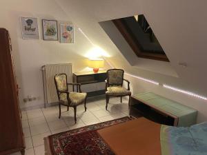 a room with a table and two chairs and a lamp at Chez Corinne et Michel in Saasenheim +4 photos