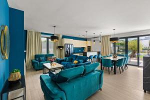 a living room with blue couches and a dining room at Villa 7Eight Banjole in Banjole