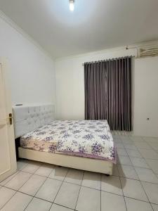 a bedroom with a bed in a white room at Villa puncak 3 room in Cikundul