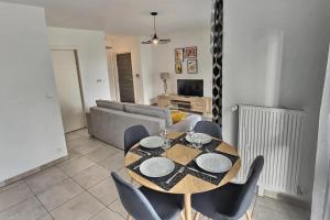 a dining table and chairs in a living room at 50m2 côté Bâle parking inclus in Saint-Louis