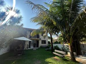 a yard with a bench and palm trees at Pousada do Coco in Abraão