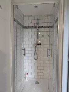 a bathroom with a shower with white tiles at Le Rocher au Thym in Limoux +13 photos