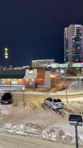 two cars parked in a parking lot in front of a building at ЖК Central Park in Aktobe