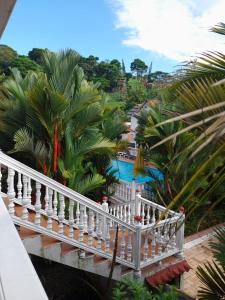 a balcony of a house with palm trees and a pool at Hotel Campestre La Toscana in Villavicencio