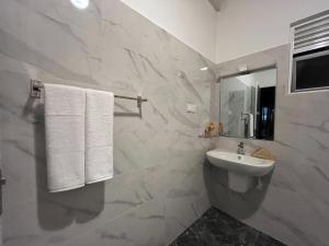 a white bathroom with a sink and a mirror at Beach Garden in Weligama