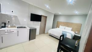 a hotel room with a bed and a kitchen at Mjee's Guest House in Ulundi +13 photos