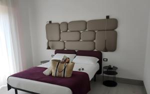 a bedroom with a bed with a large headboard at Hotel Belvedere in Sottomarina