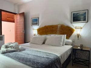 a bedroom with a large bed with a wooden headboard at Hotel Pousada 360 in Paracuru