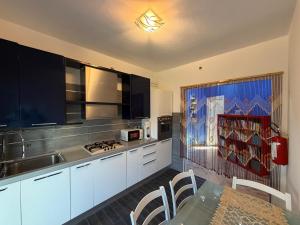 a kitchen with white cabinets and a sink and a table at Casa Raffinata in Mestre