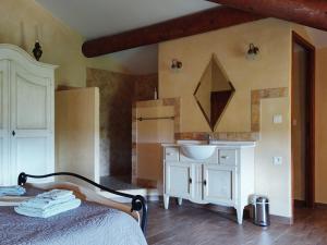 a bedroom with a bed and a sink and a refrigerator at Ferme de Palumiane - Chambres climatisées in Visan