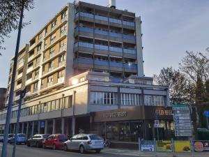a tall building with cars parked in front of it at Apartments Marini in Pordenone