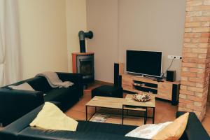 a living room with a black couch and a fireplace at Beachside Guest House Piejuras nams in Ķesterciems +38 photos