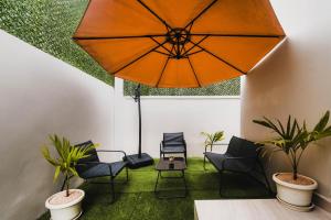 a room with chairs and a large umbrella at Villa Clif-Beau in Albion
