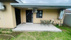 a patio with chairs and a table in front of a house at Mjee's Guest House in Ulundi