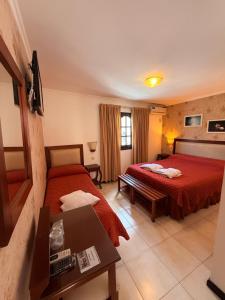a hotel room with two beds and a table at Posada de Las Farolas in Salta