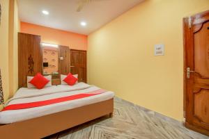 a bedroom with a bed with red pillows on it at Super Hotel O Priyal Amrit Sagar in Rourkela