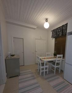 a kitchen and dining room with a table and chairs at Huoneisto Kuusi in Kokkola
