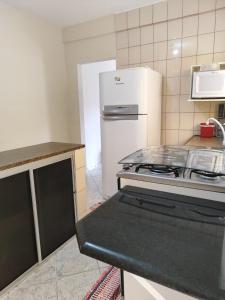 a kitchen with a stove and a white refrigerator at Casa da Cissa in Matinhos +7 photos