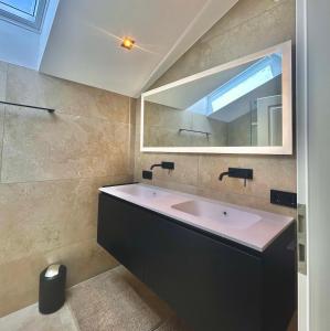 a bathroom with a sink and a mirror at Ferienwohnung "Krainsbergkogel" - Edles Dachgeschossapartment mit Bergblick in Schliersee