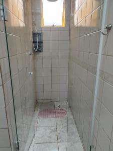 a bathroom with a shower with a glass door at Casa da Cissa in Matinhos