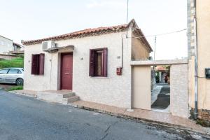 a white building with a red door on a street at Andreas House in Valíra