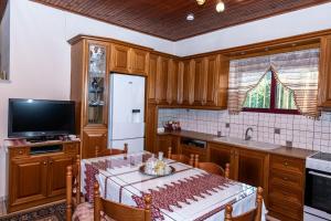 a kitchen with a table and a tv and a table and chairs at Andreas House in Valíra +24 photos