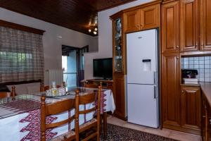 a kitchen with a table and a white refrigerator at Andreas House in Valíra