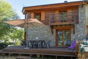 a patio with a table and chairs and an umbrella at Chalet Edliane in Font-Romeu-Odeillo-Via