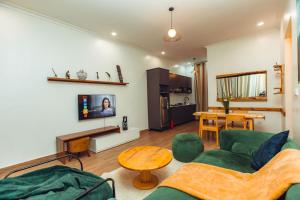 a living room with a green couch and a table at Makeri Residence - Musanze , Rwanda in Ruhengeri